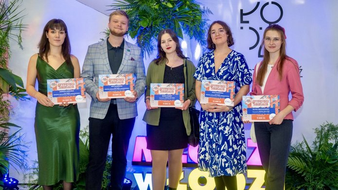 Grupa osób pozujących do zdjęcia i trzymających dyplomy